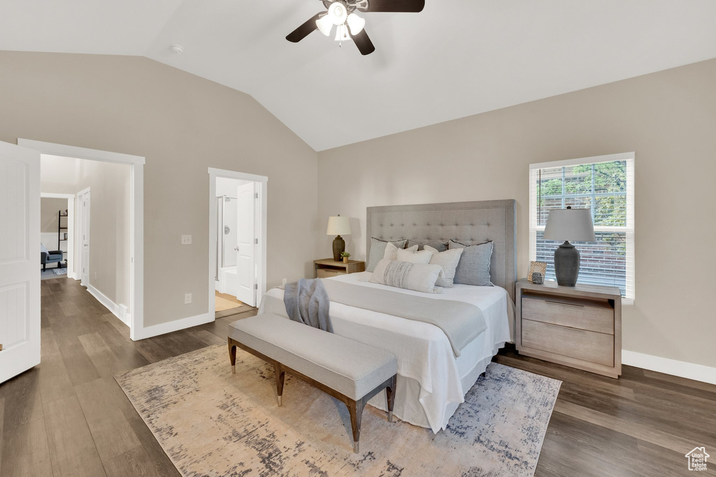 Bedroom with vaulted ceiling, wood finished floors, baseboards, ceiling fan, and ensuite bath