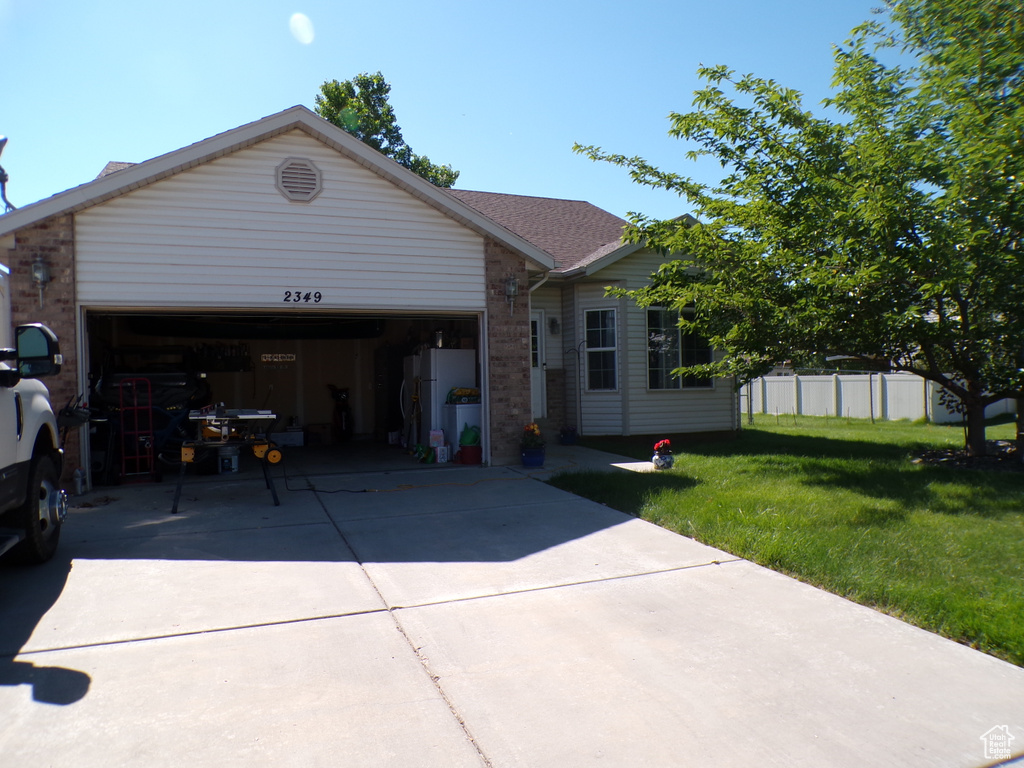 Ranch-style house with an attached garage, brick siding, a front yard, and concrete driveway