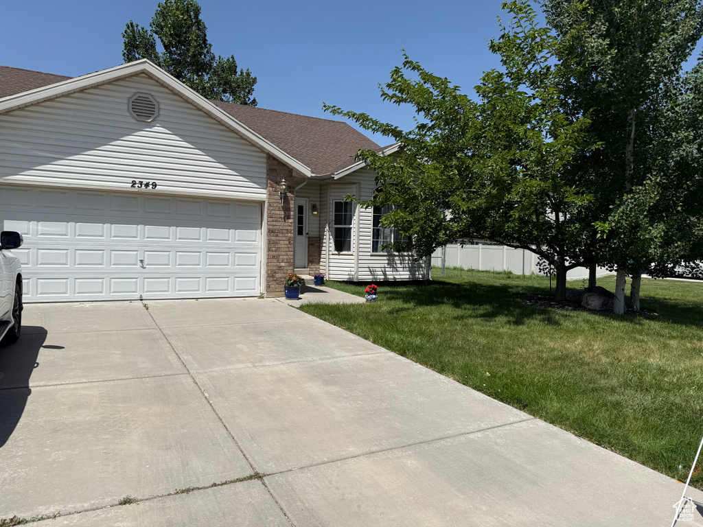 Ranch-style home featuring driveway, a garage, brick siding, and roof with shingles