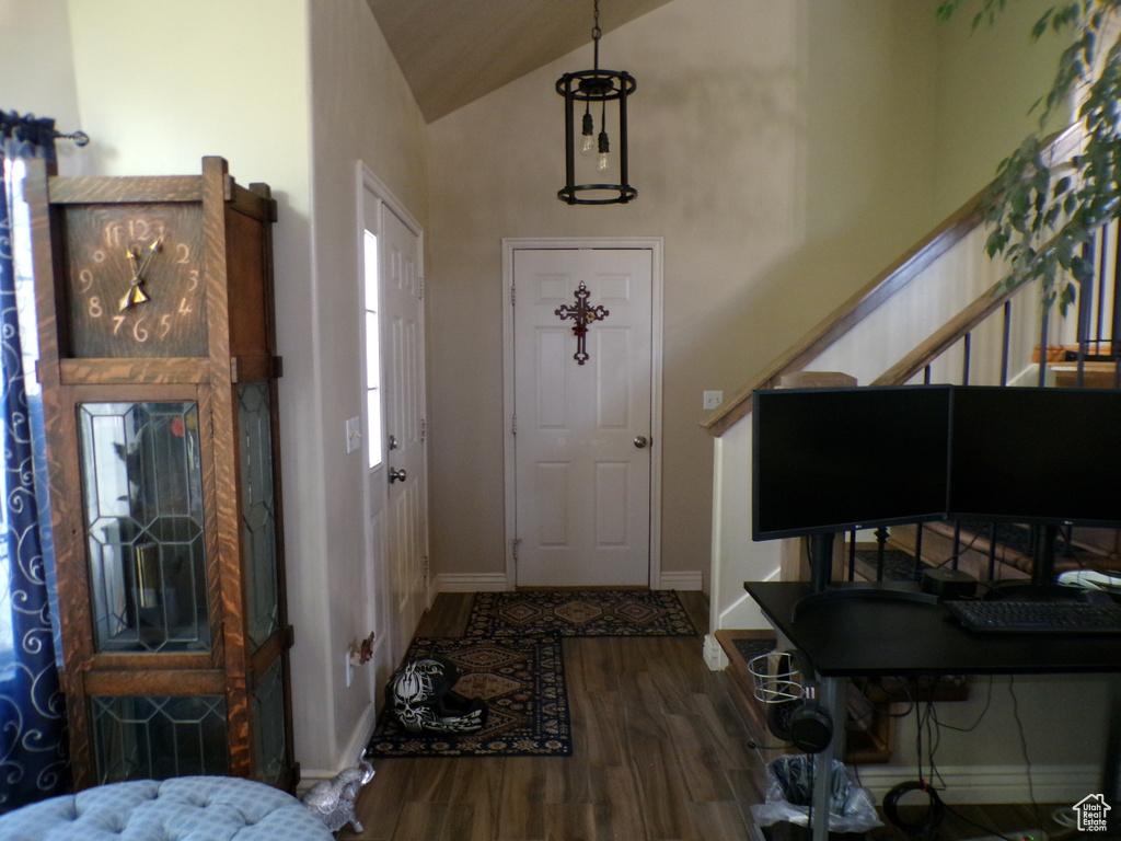 Entryway with wood finished floors, baseboards, and high vaulted ceiling