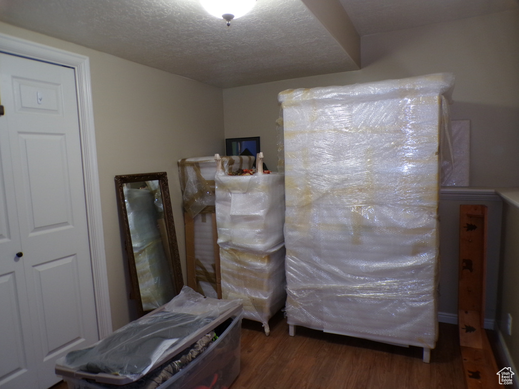 Bedroom with wood finished floors and a textured ceiling