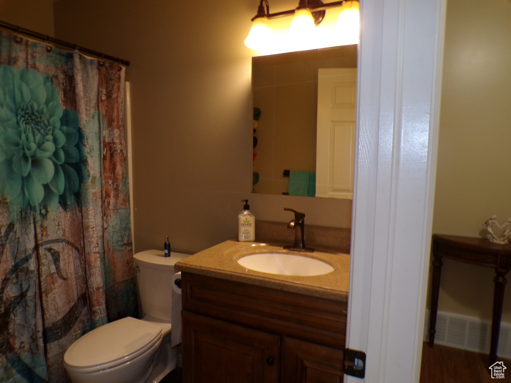 Bathroom featuring vanity, toilet, and a shower with shower curtain