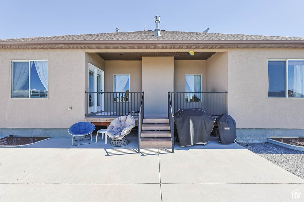 Back of house with a patio, stucco siding, and roof with shingles