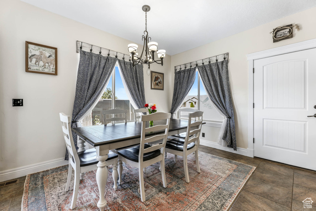Dining area featuring a chandelier, healthy amount of natural light, and baseboards