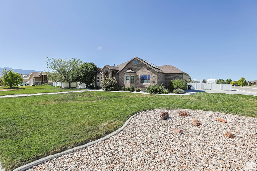 View of front of property featuring roof mounted solar panels and brick siding