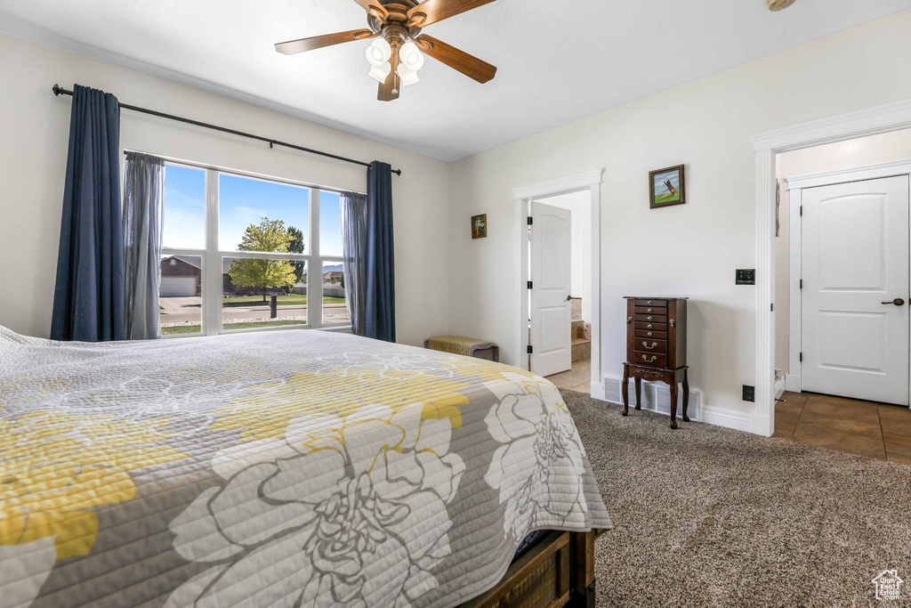 Carpeted bedroom featuring baseboards, a ceiling fan, tile patterned flooring, and connected bathroom