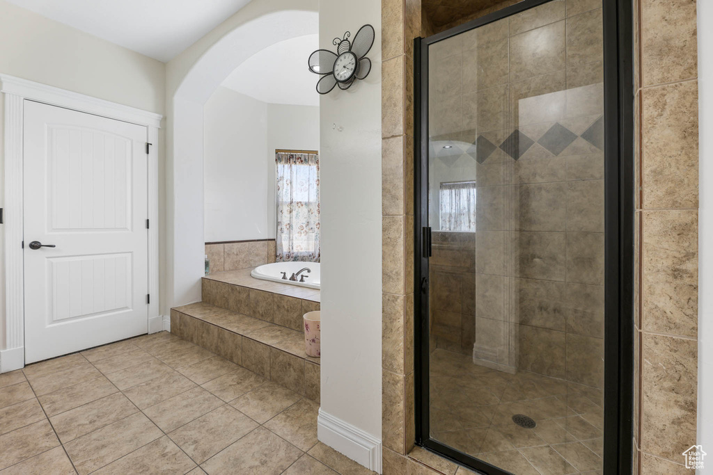 Bathroom featuring tile patterned flooring, a garden tub, and a stall shower
