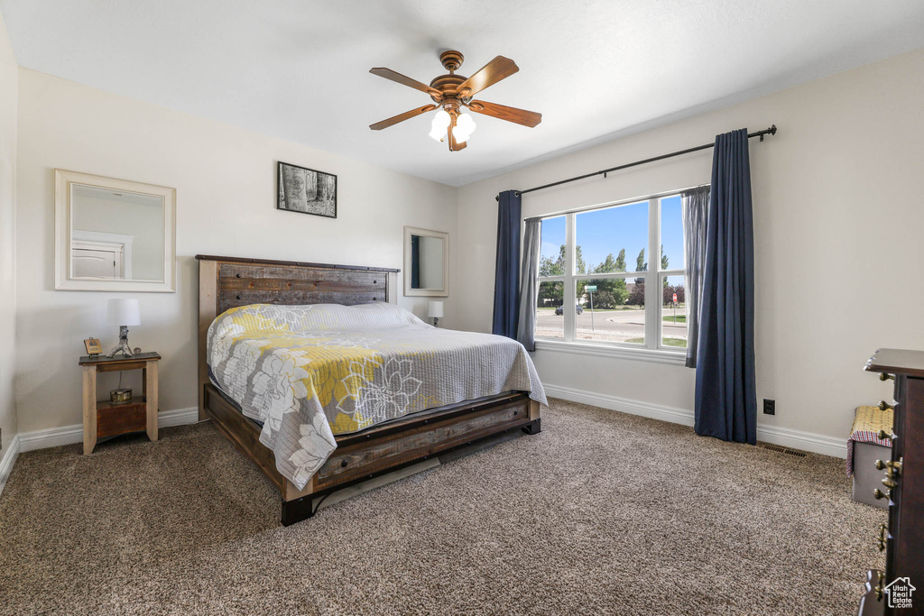 Carpeted bedroom featuring baseboards and a ceiling fan