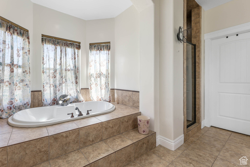 Bathroom with a garden tub, tile patterned flooring, and a shower with shower door
