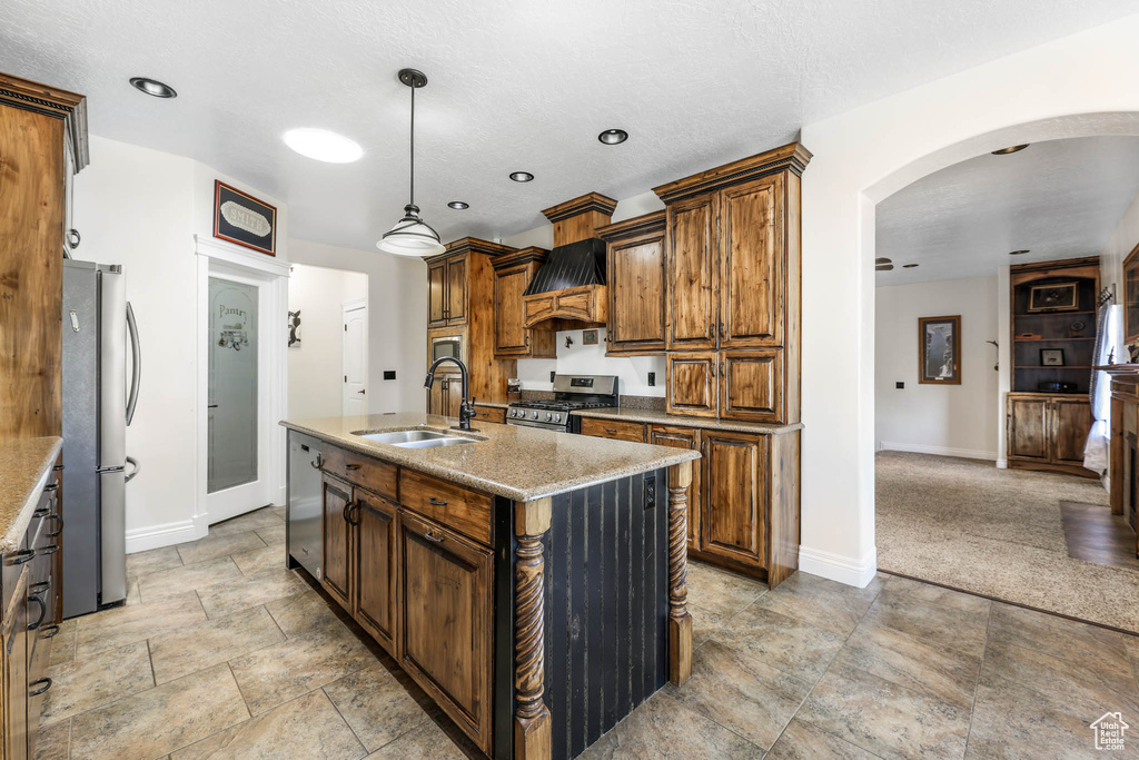 Kitchen with appliances with stainless steel finishes, arched walkways, a sink, and baseboards