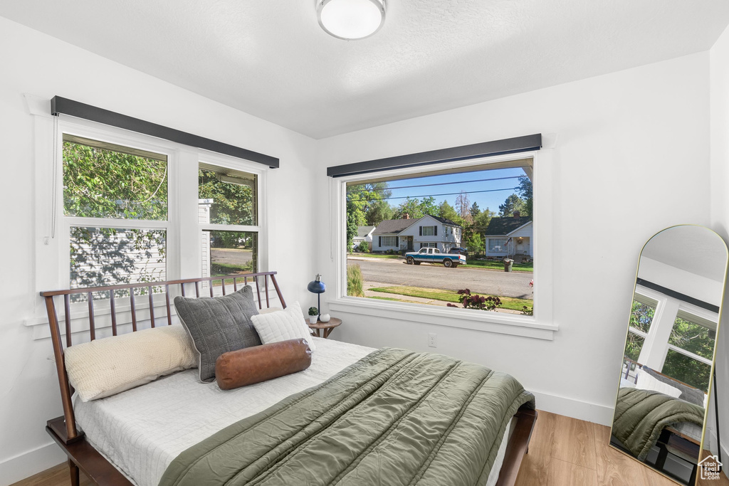 Bedroom with wood finished floors and baseboards