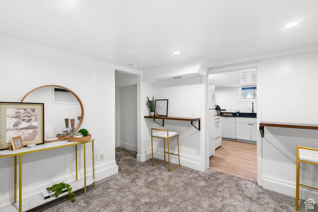 Empty room with light colored carpet, recessed lighting, and baseboards