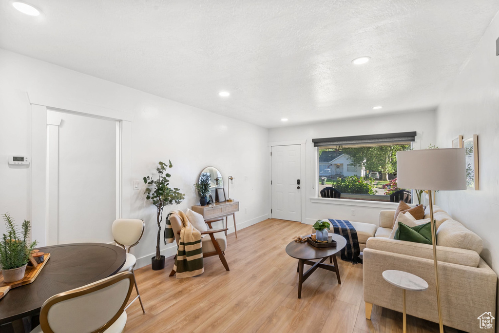 Living room with light wood-style floors, recessed lighting, and baseboards