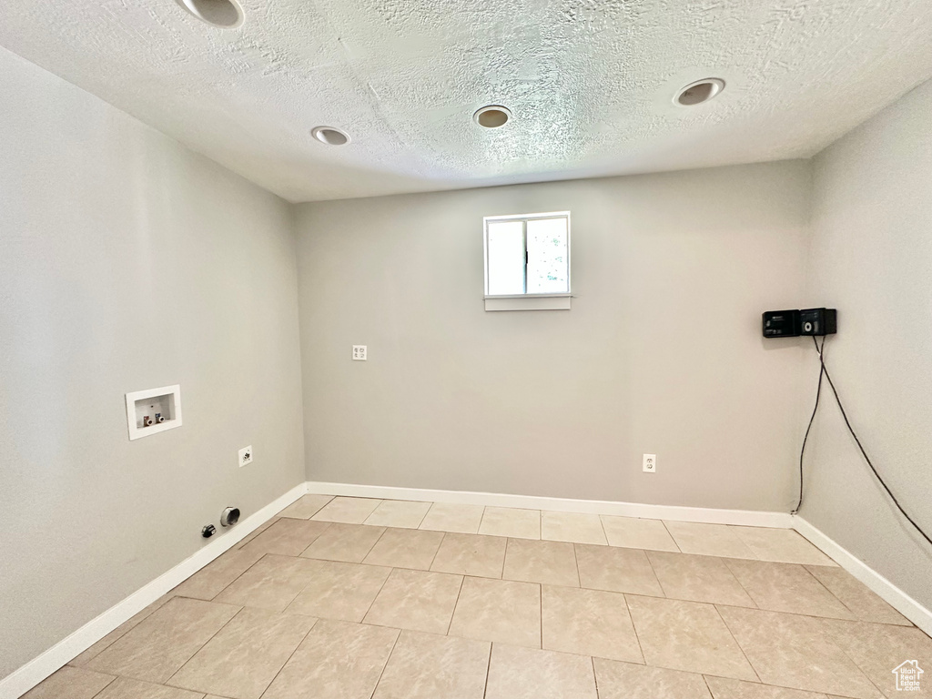 Laundry area featuring washer hookup, hookup for a gas dryer, hookup for an electric dryer, light tile patterned flooring, and baseboards