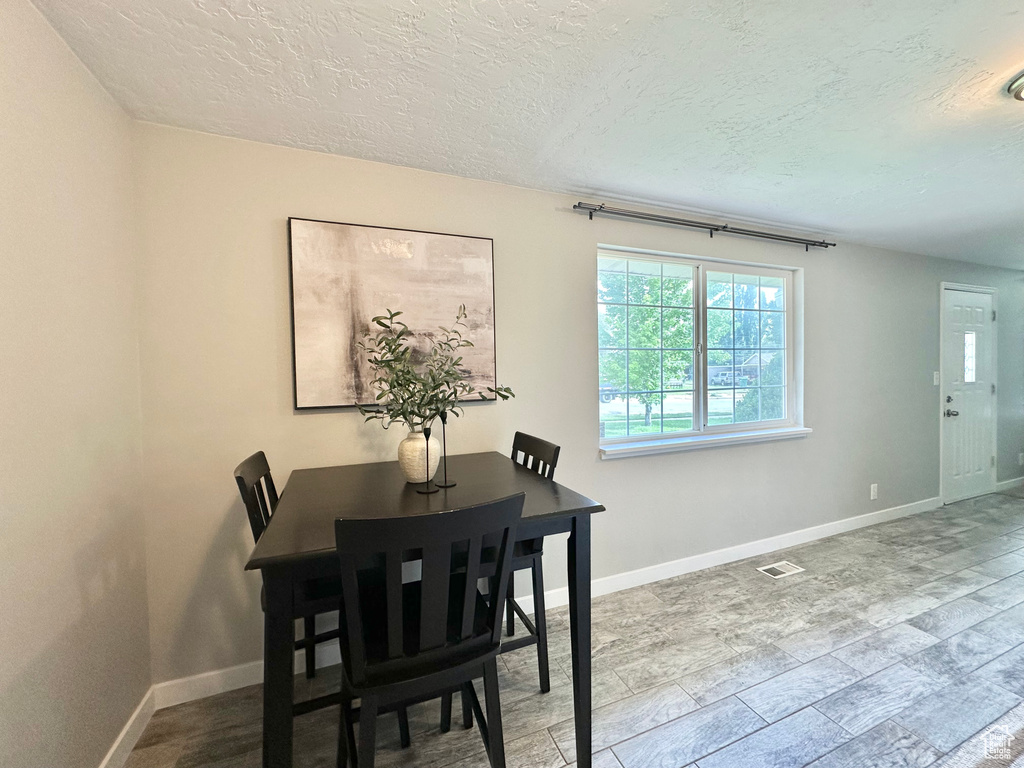 Dining room featuring a textured ceiling and baseboards