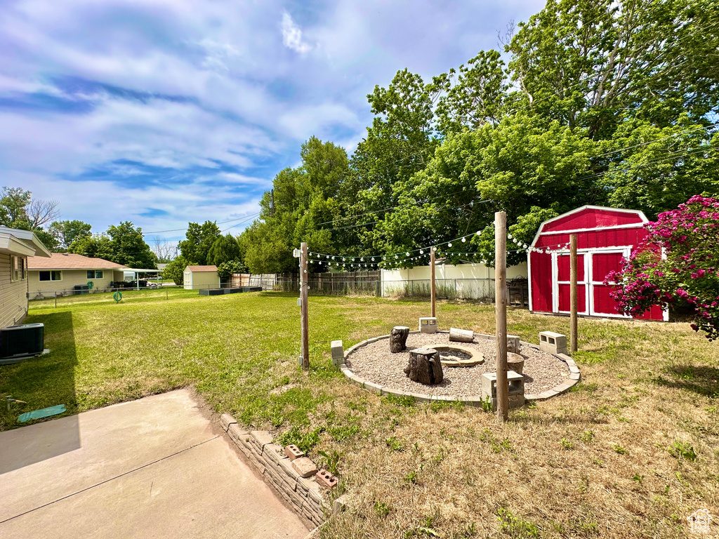 View of yard with an outdoor fire pit, central AC, and a patio