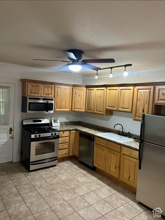Kitchen featuring appliances with stainless steel finishes, a sink, ceiling fan, and light tile patterned floors