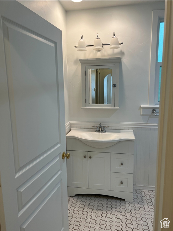 Bathroom with vanity, wainscoting, and tile patterned floors
