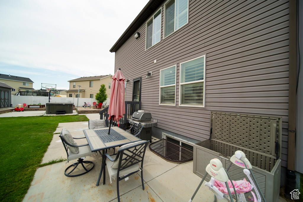 View of patio / terrace featuring a hot tub, outdoor dining space, central air condition unit, and a grill