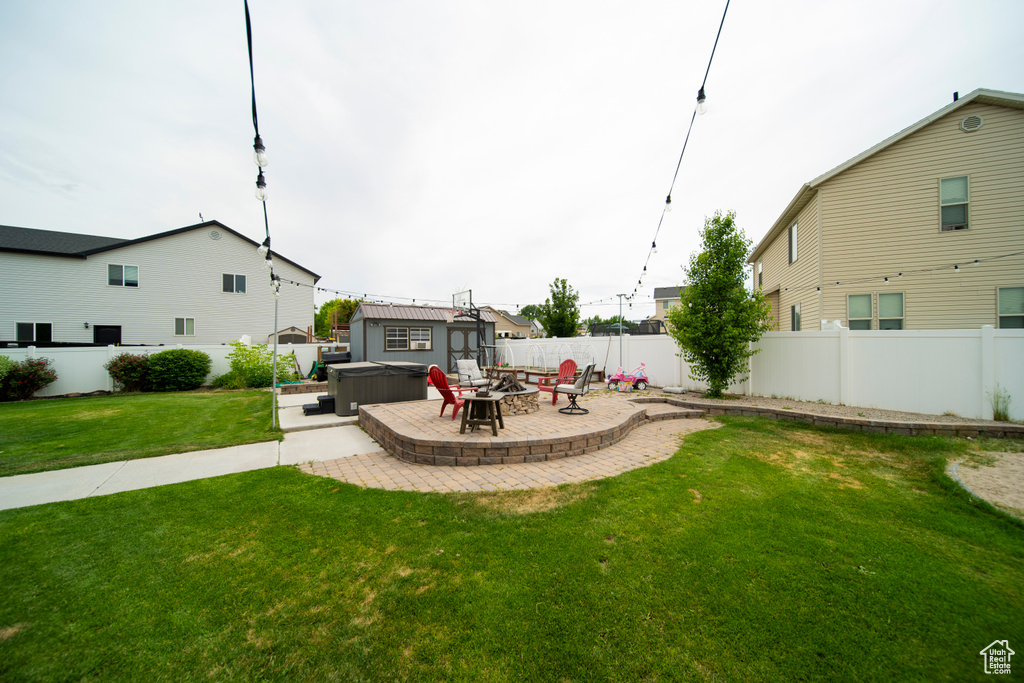 View of yard featuring a hot tub, a patio, and an outdoor fire pit