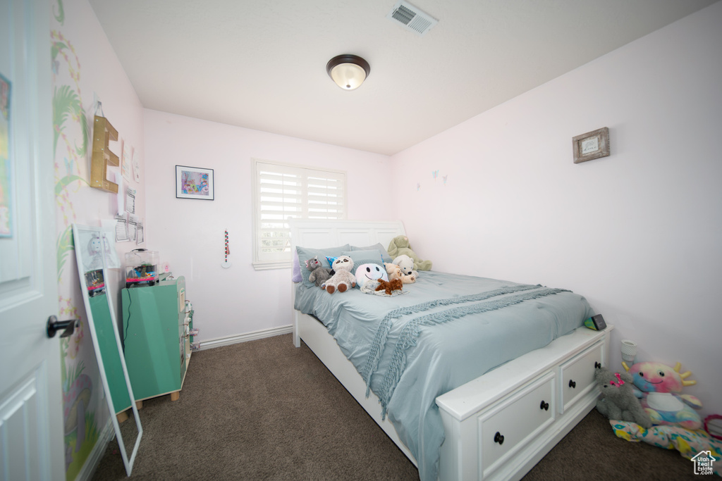 Bedroom with dark colored carpet and baseboards