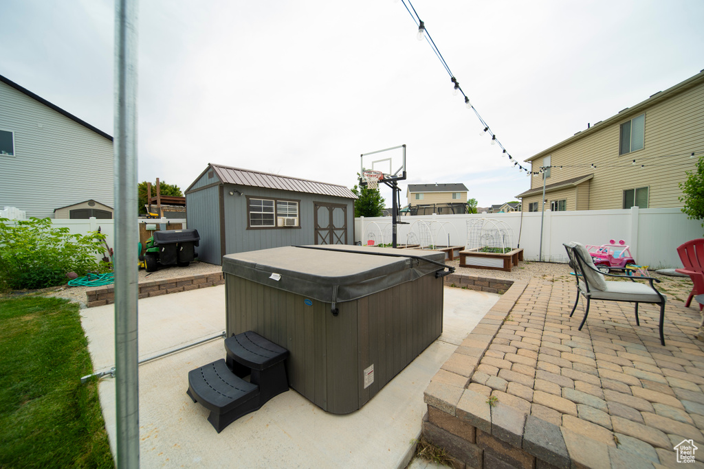 Fenced backyard with a hot tub and a patio