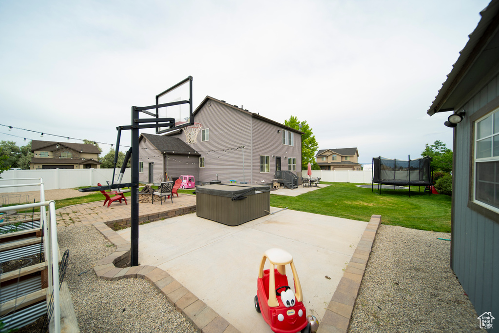 View of patio / terrace featuring a trampoline and an outdoor fire pit