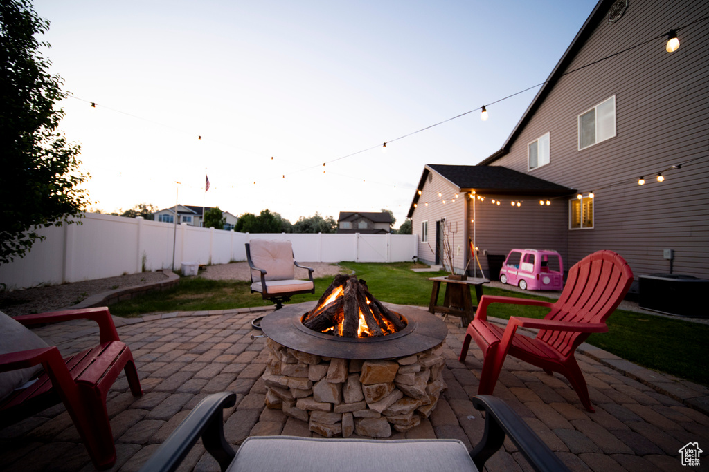 Fenced backyard featuring an outdoor fire pit, central AC unit, and a patio