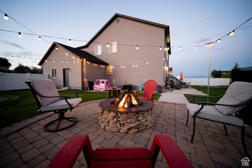 Fenced backyard with a fire pit, a patio, and a gate