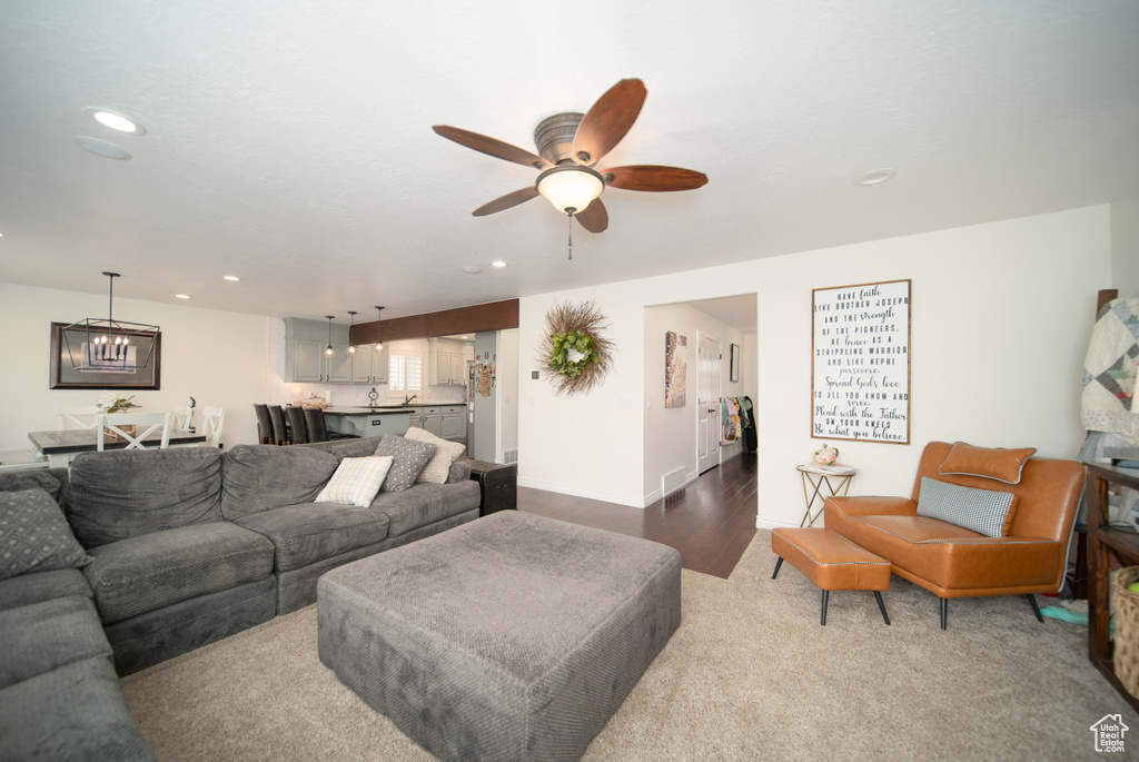 Living area with a ceiling fan, recessed lighting, a chandelier, and baseboards