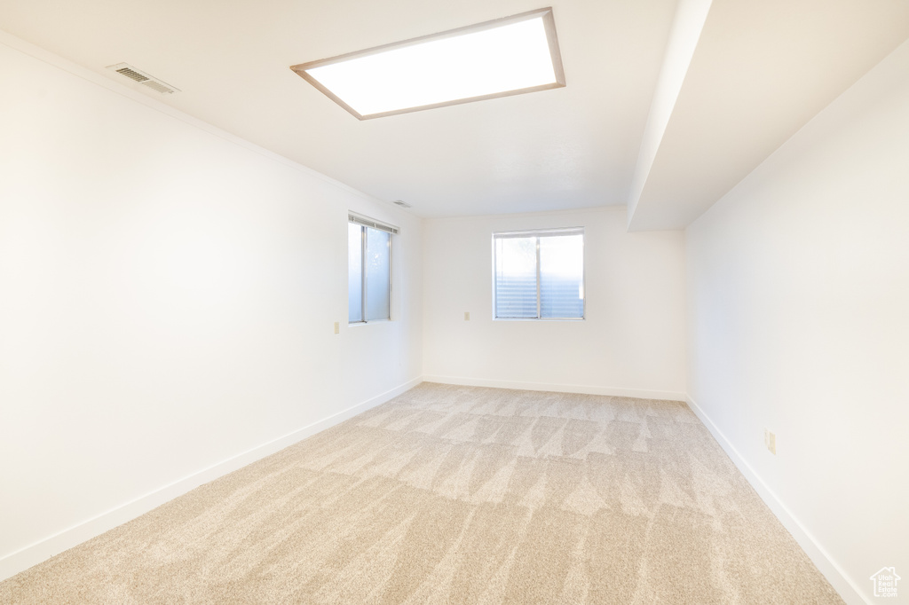 Empty room with light carpet and baseboards