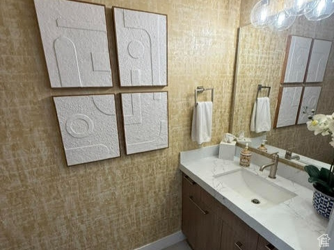 Bathroom with vanity, toilet, baseboards, and marble finish floors