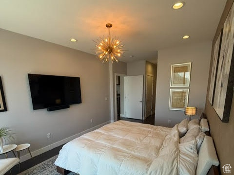 Bedroom featuring a chandelier, baseboards, recessed lighting, and wood finished floors