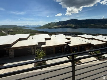 Balcony featuring a water and mountain view