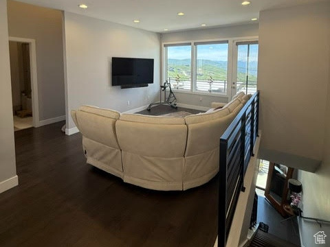 Living room with dark wood-style flooring, baseboards, and recessed lighting