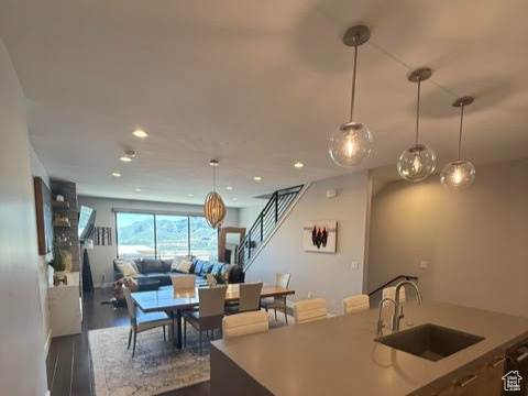 Kitchen with a sink, open floor plan, dark wood finished floors, pendant lighting, and recessed lighting