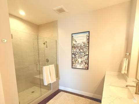 Bathroom with baseboards, a stall shower, and vanity