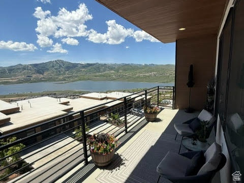 Balcony featuring a water and mountain view
