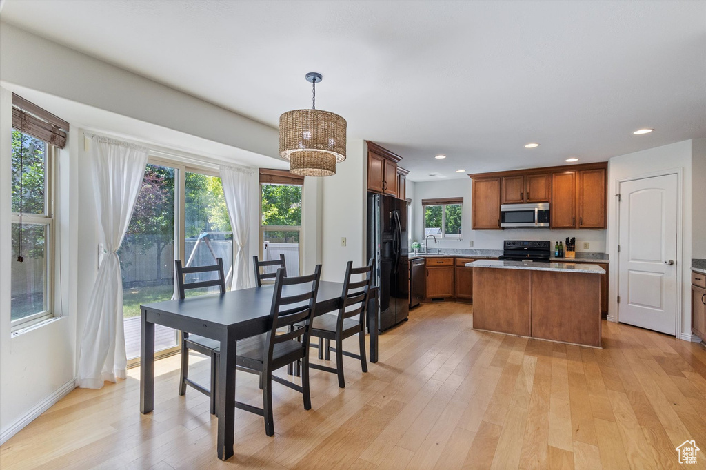 Dining space with light wood-style floors and recessed lighting