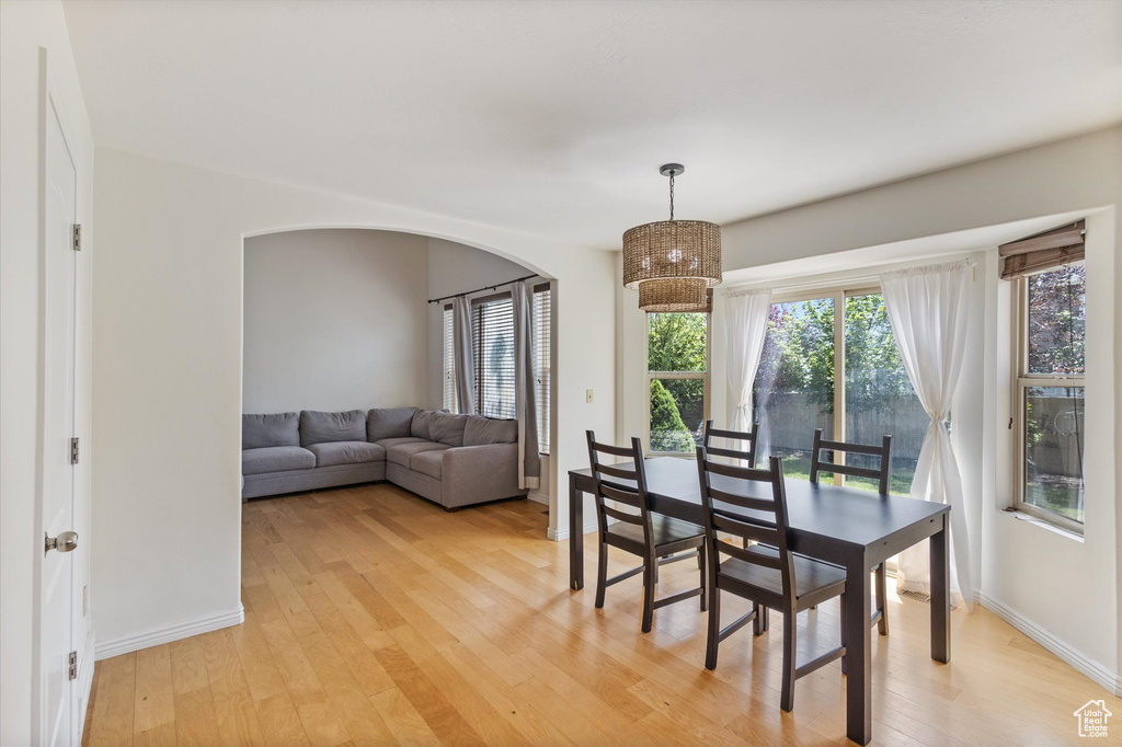 Dining space featuring light wood-type flooring and arched walkways