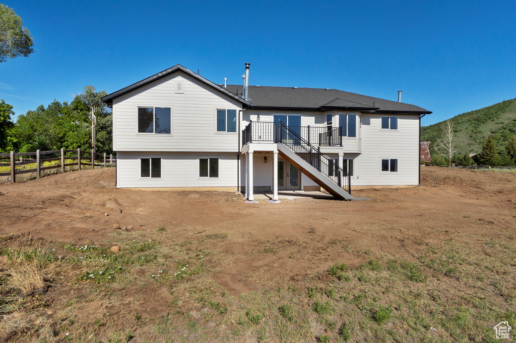 Rear view of property with stairs and a wooden deck