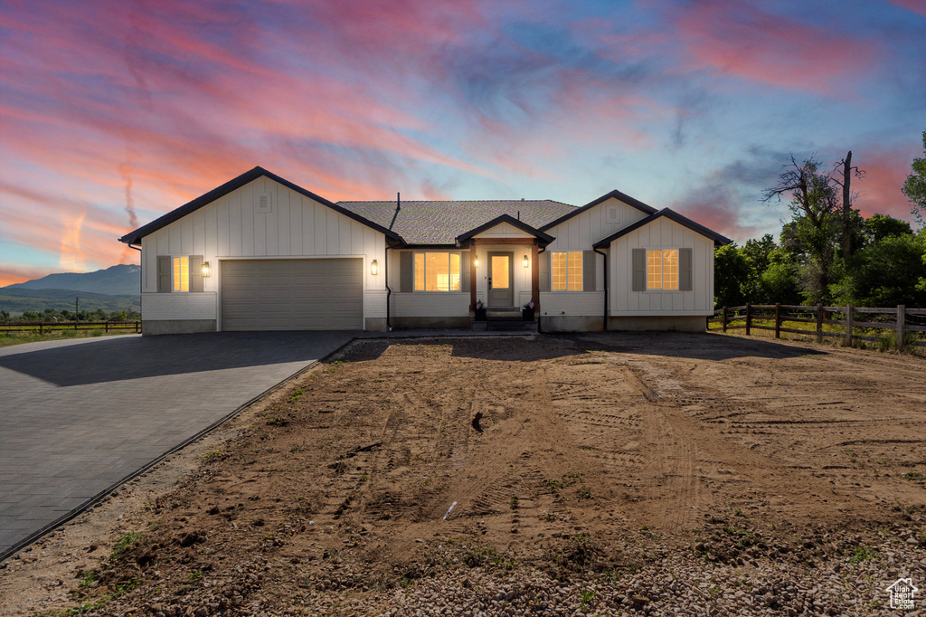 View of front of property featuring a garage, driveway, and board and batten siding