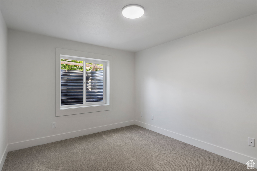 Spare room featuring carpet and baseboards