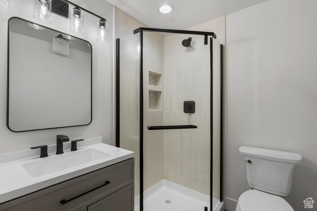 Full bath featuring toilet, vanity, and a stall shower