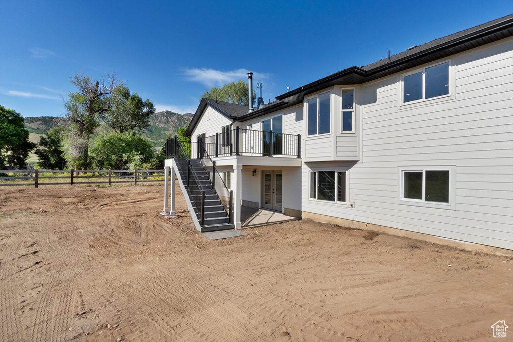 Back of house featuring stairway, french doors, and a deck with mountain view