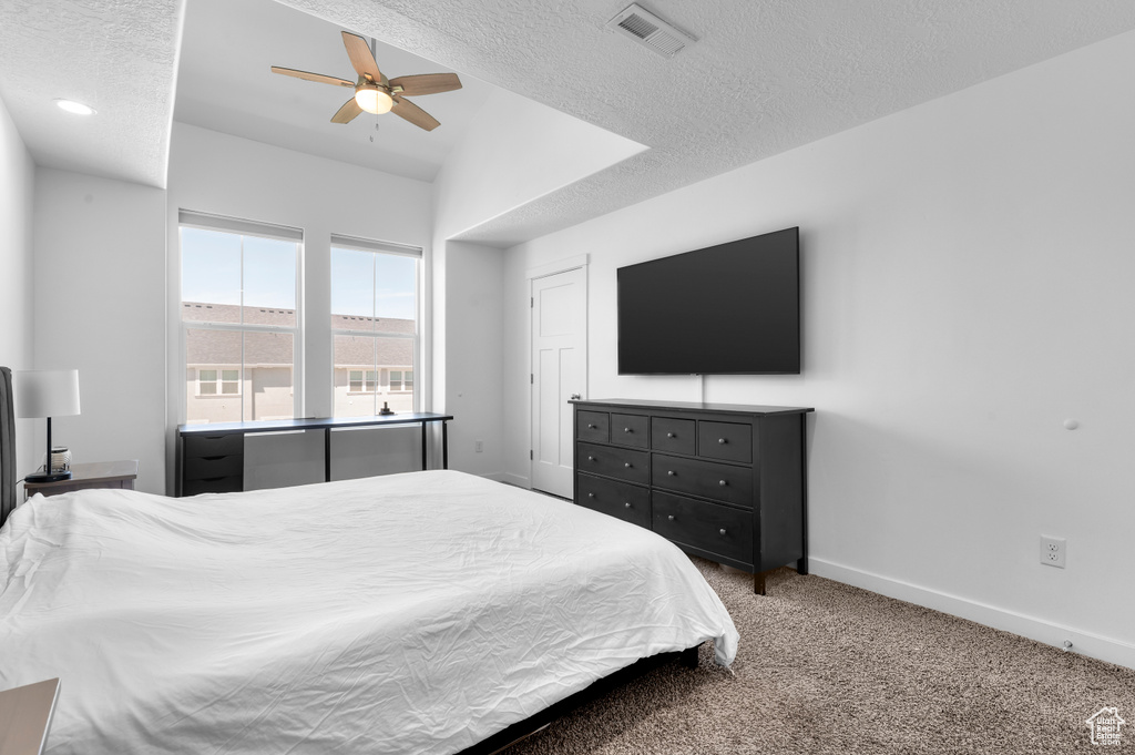 Bedroom featuring carpet flooring, baseboards, a textured ceiling, and ceiling fan