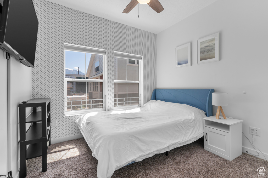 Bedroom with carpet, baseboards, a ceiling fan, and wallpapered walls