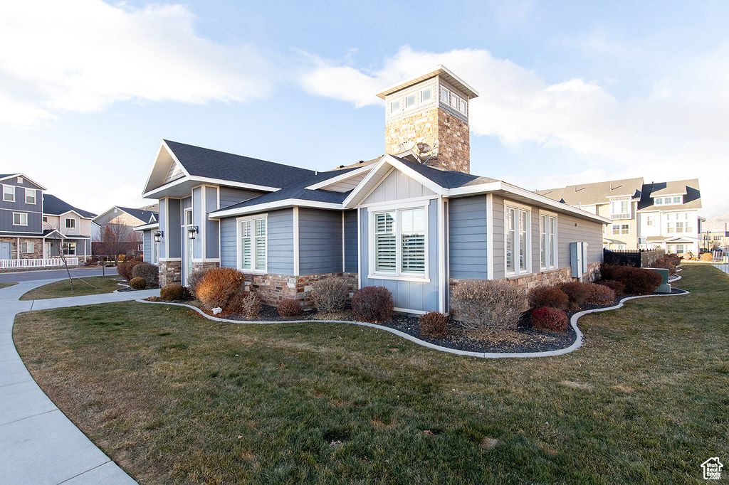 View of home's exterior with stone siding, board and batten siding, a lawn, and a residential view