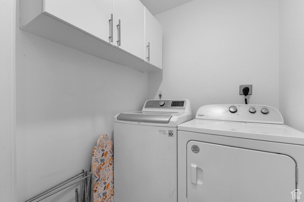 Laundry room featuring separate washer and dryer and cabinet space
