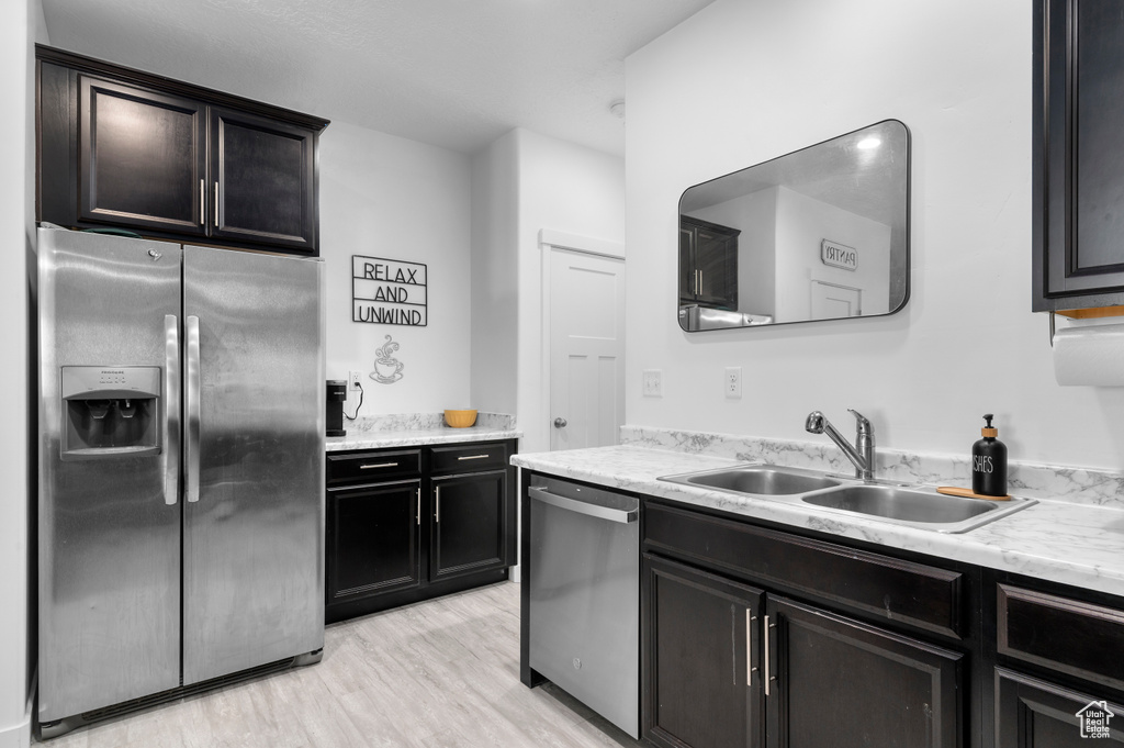Kitchen featuring stainless steel appliances, a sink, and light wood-type flooring